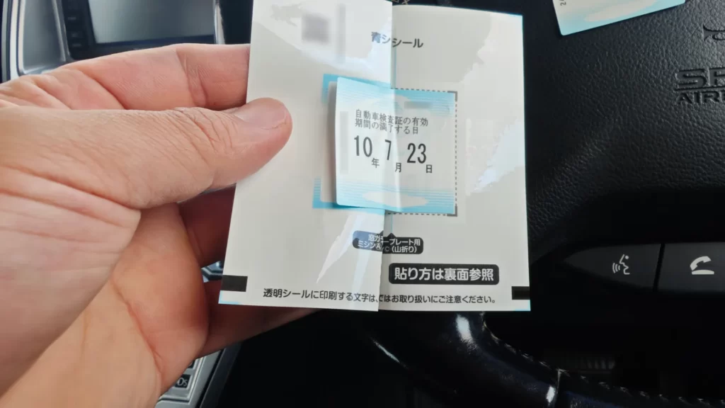 車検ステッカーの青シールを貼り合わせるために台紙を折った状態