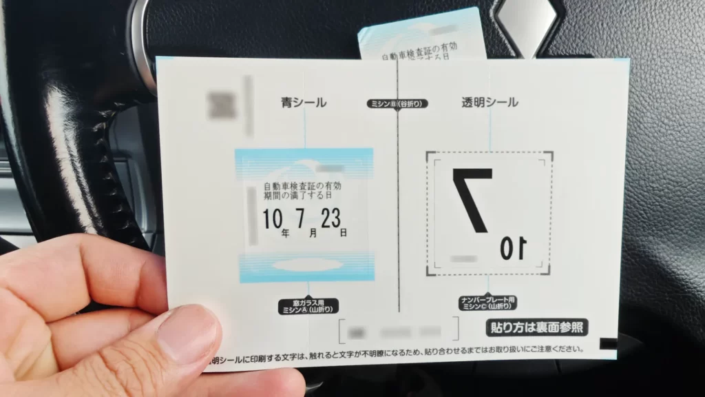 新しい車検ステッカーと貼り付け用の説明台紙